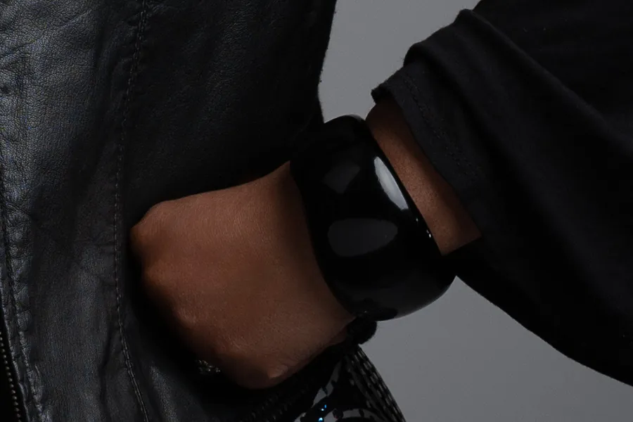 Detail: a hand on the hip, black cuff and leather